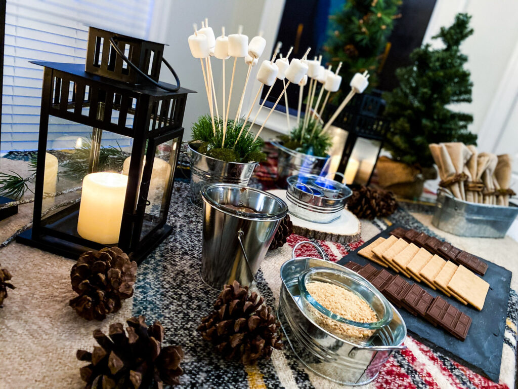 A cute campfire tablescape is the perfect set up for this s'mores bar station, which is a way to celebrate National S'mores Day, as well as how to make indoor s'mores at home.