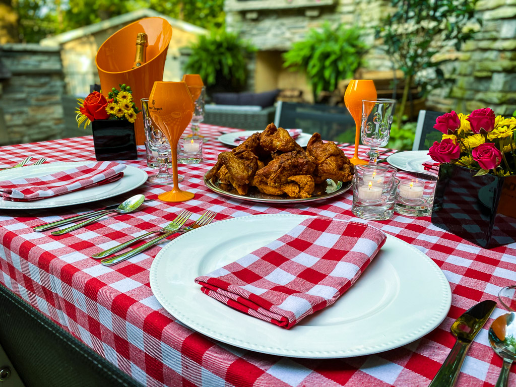 A southern style table setting for a dinner pairing fried chicken and champagne