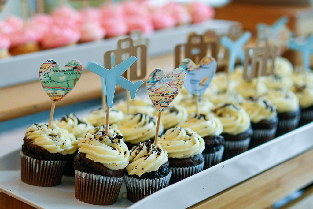 Travel themed picks including a map, plane and suitcase inserted into chocolate cupcakes are a great and simple idea to incorporate a travel theme. 