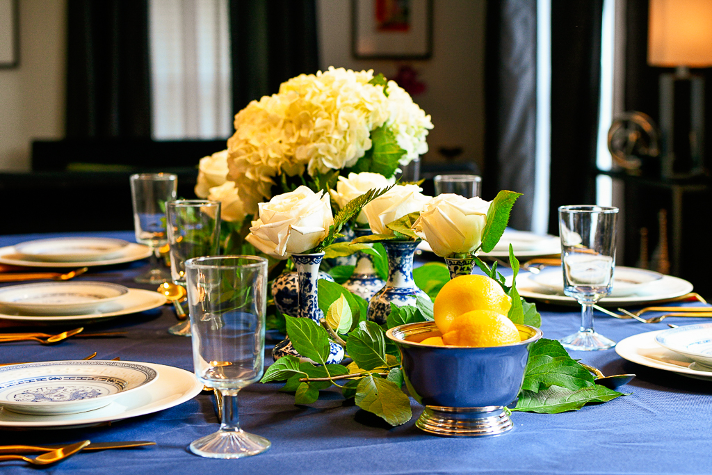 Blue tablecloth, silver bowl with lemons, hydrangeas in a chinoiserie ginger jar.