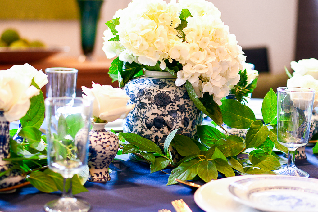 A blue and white chinoiserie ginger jar with white hydrangeas is a perfect centerpiece for the blue table setting.