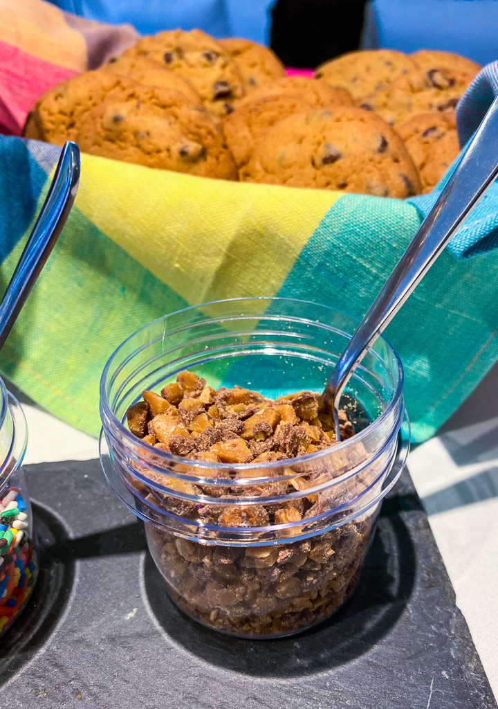 Build your own ice cream sandwich dessert with a DIY bar, chocolate chip cookies in a basket with a pastel plaid napkin, chopped up heath bar.
