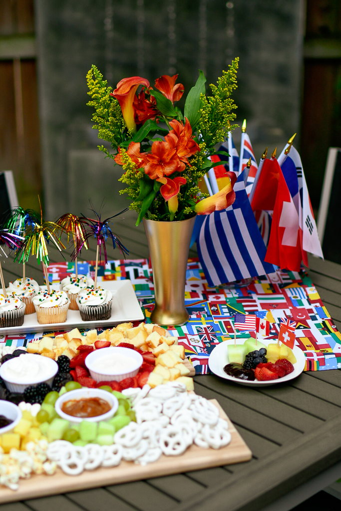 This Olympic party idea is a tablescape set with Olympic decor including an Olympic flame and Olympic torch, as well as a charcuterie board with food int he shape of the Olympic rings. Olympic party ideas.