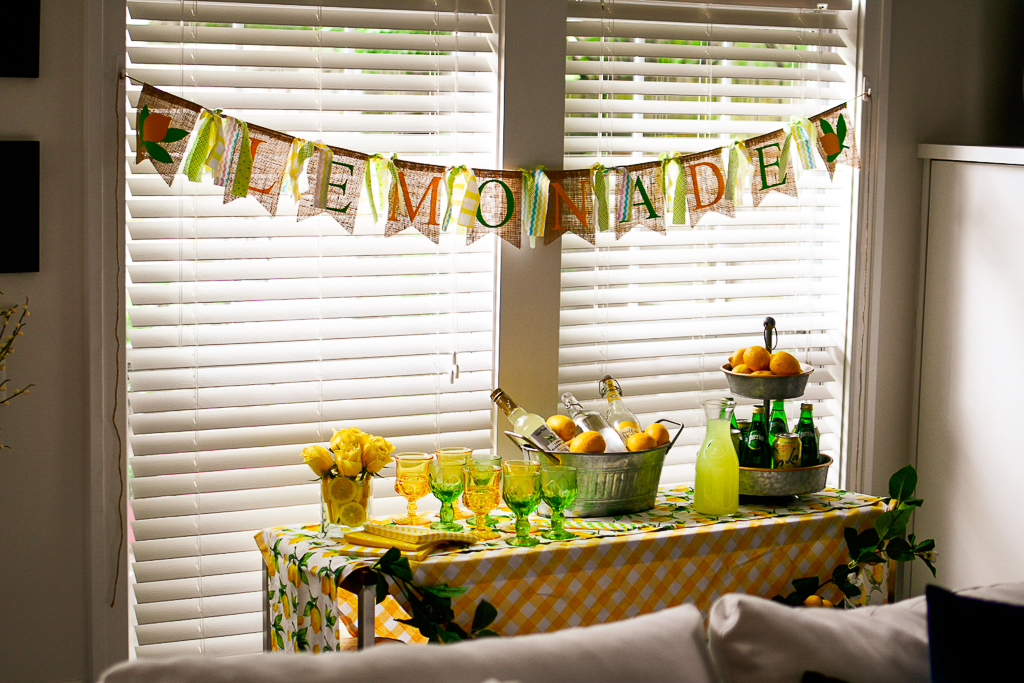 A great summer party themes is a DIY  lemonade stand ideas with is also a cute lemonade stand ideas. It include the best limoncello recipe, lemonade cocktail recipes and lemonade party ideas, a DIY burlap lemonade banner, galvanized pails, white and yellow check tablecloth, lemon table runner, galvanized tiered metal tray with lemons, vintage green glassware, vintage yellow glassware, and lemon garland.